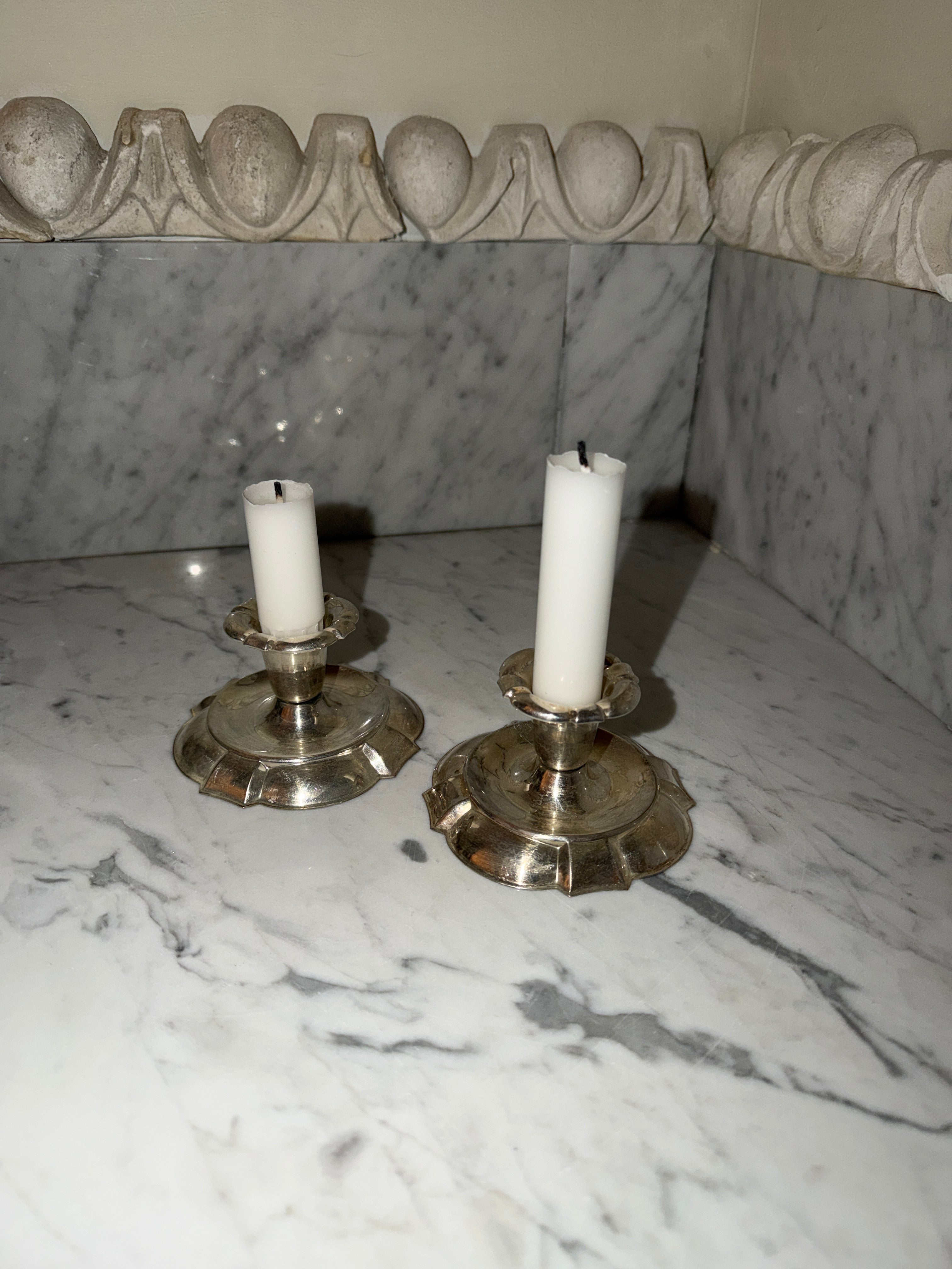 A pair of candlesticks in new silver